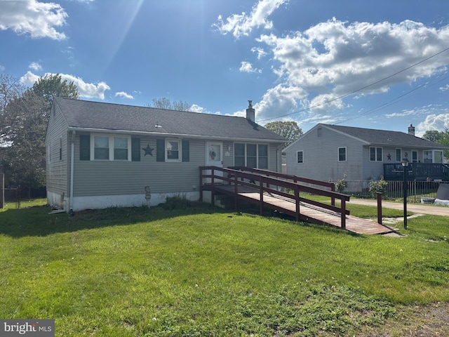 view of front of house with fence, a chimney, and a front yard