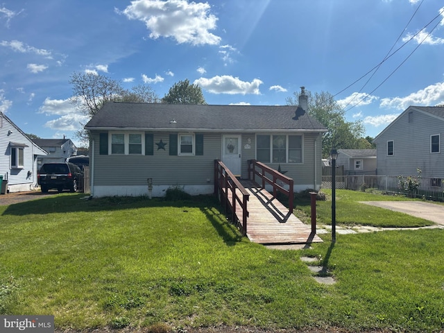 view of front of property with fence, a chimney, and a front yard