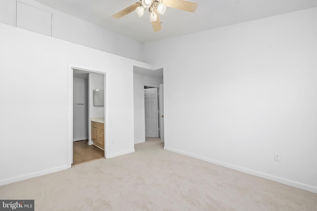 unfurnished bedroom with light colored carpet, baseboards, ensuite bath, ceiling fan, and lofted ceiling