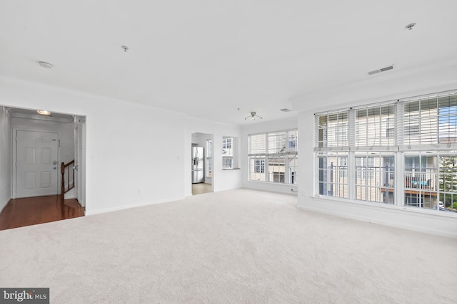 unfurnished living room featuring carpet flooring and baseboards