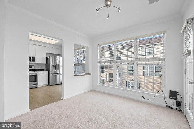 unfurnished living room featuring light carpet, crown molding, and baseboards