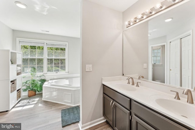 13213 Windy Leaf Ct, Woodbridge, VA 22192 - bathroom featuring a sink, a bath, double vanity, and wood finished floors