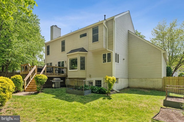 13213 Windy Leaf Ct, Woodbridge, VA 22192 - back of house with a chimney, a wooden deck, a vegetable garden, fence, and a yard