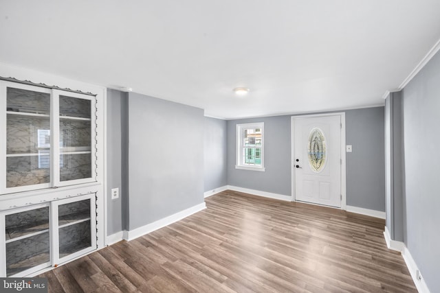 foyer featuring baseboards and wood finished floors