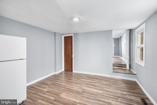 interior space featuring baseboards, visible vents, and wood finished floors