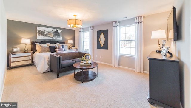 bedroom with baseboards, visible vents, and light colored carpet