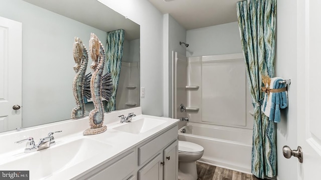 full bath with shower / bath combination, a sink, wood finished floors, and toilet