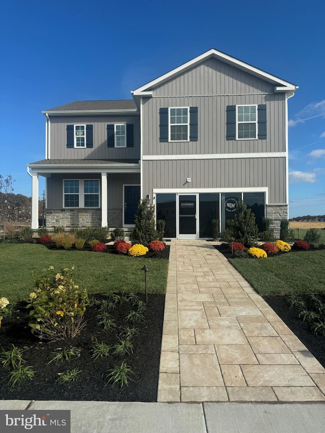 traditional-style home with a front yard and stone siding
