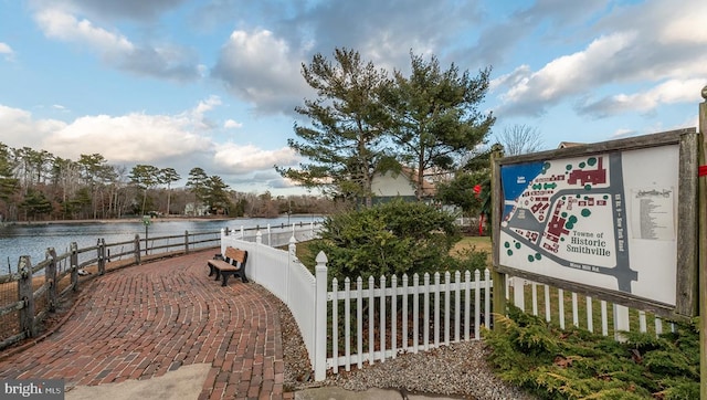 view of property's community featuring fence and a water view