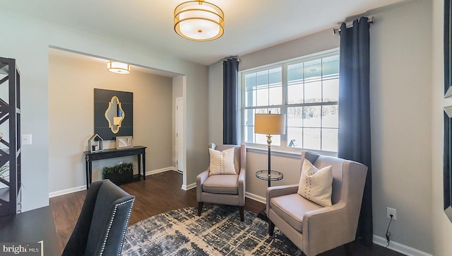 living area featuring baseboards and wood finished floors
