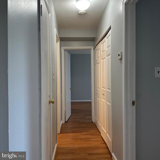 hallway with baseboards and wood finished floors