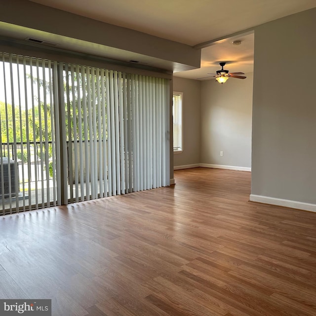 empty room featuring baseboards, ceiling fan, and wood finished floors