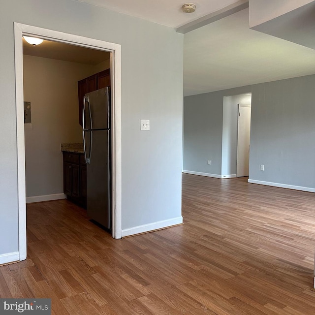 empty room with baseboards and wood finished floors