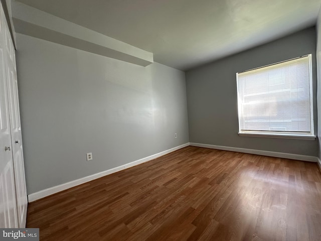 empty room with baseboards and wood finished floors