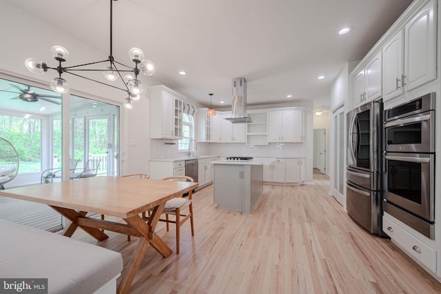 kitchen featuring plenty of natural light, open shelves, island range hood, and stainless steel appliances