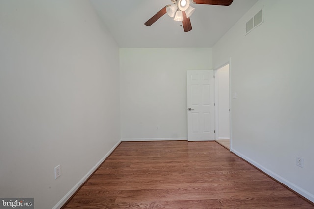 unfurnished room with visible vents, baseboards, ceiling fan, and wood finished floors
