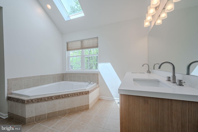 full bath with lofted ceiling with skylight, a sink, a bath, and tile patterned floors