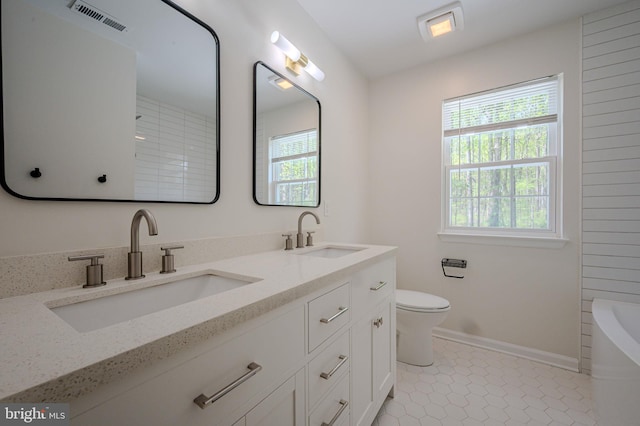 full bathroom with visible vents, a sink, toilet, and a washtub
