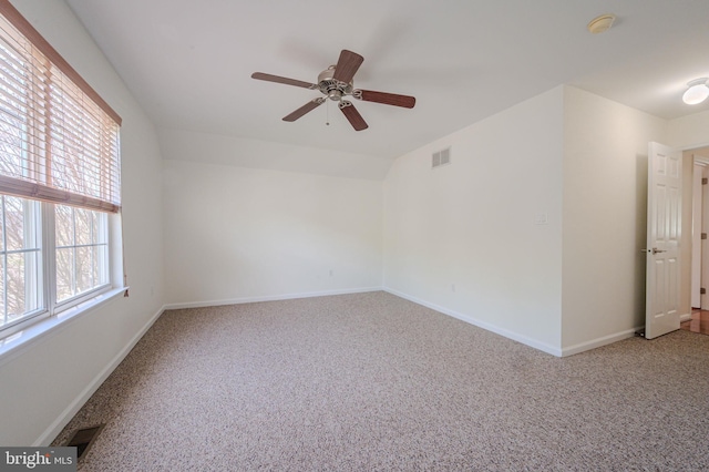 carpeted empty room featuring visible vents, baseboards, and ceiling fan