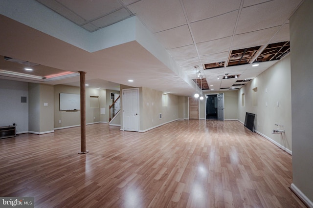 finished below grade area with stairs, recessed lighting, baseboards, and wood finished floors