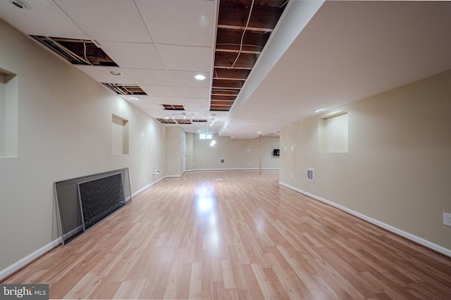 finished basement featuring baseboards, wood finished floors, and visible vents