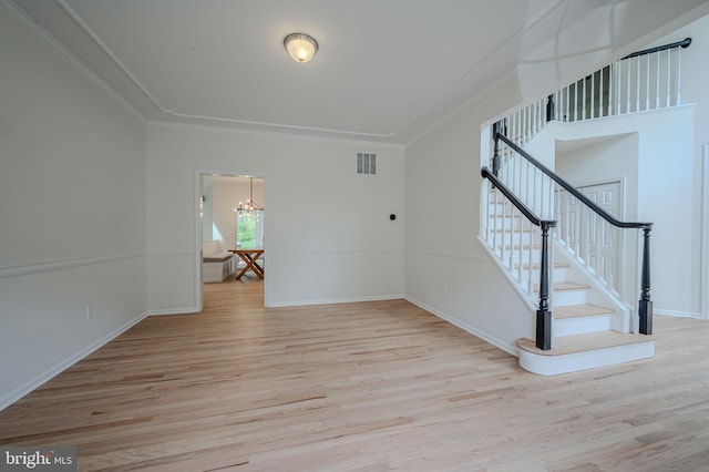 unfurnished living room featuring visible vents, light wood-type flooring, and a notable chandelier