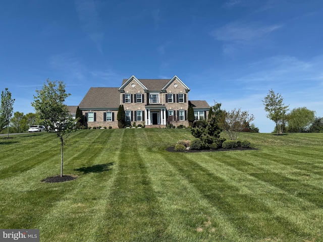 view of front of house with brick siding and a front yard