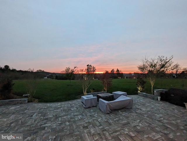 patio terrace at dusk featuring a yard
