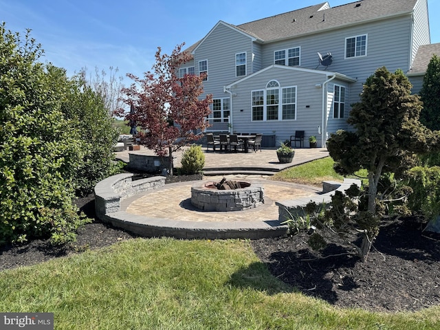 back of house featuring a patio, a shingled roof, and an outdoor fire pit