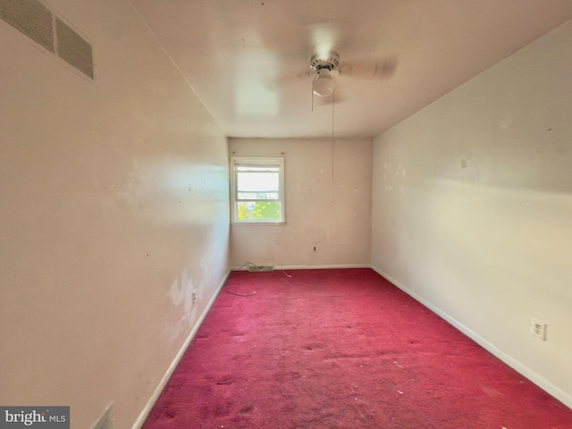 spare room featuring carpet floors, baseboards, visible vents, and ceiling fan