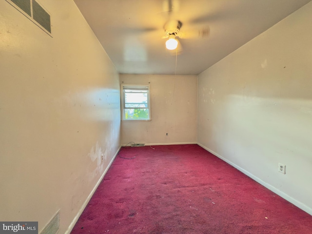 carpeted empty room with visible vents, a ceiling fan, and baseboards