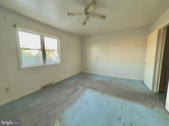 empty room featuring carpet floors and a ceiling fan
