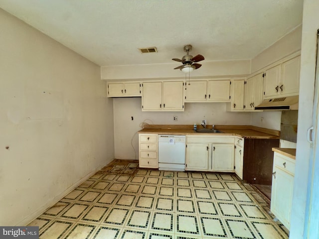 kitchen with white dishwasher, ceiling fan, a sink, light floors, and under cabinet range hood