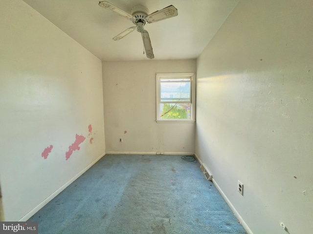 carpeted empty room with baseboards and a ceiling fan