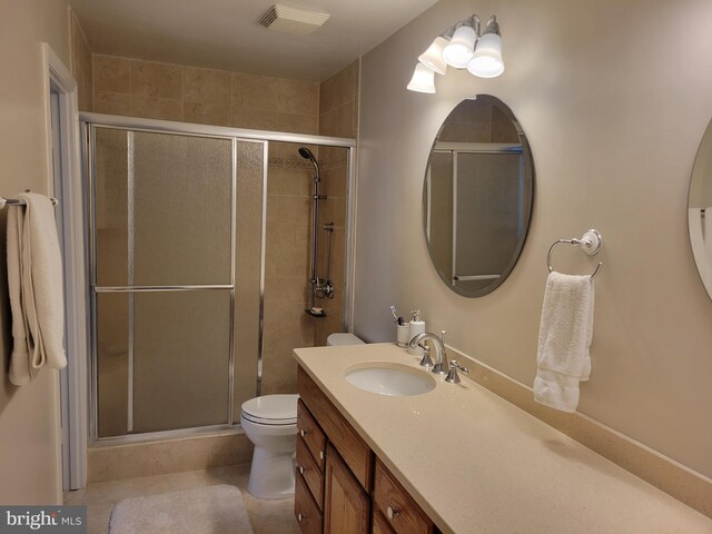 full bath featuring tile patterned flooring, vanity, visible vents, toilet, and a shower stall