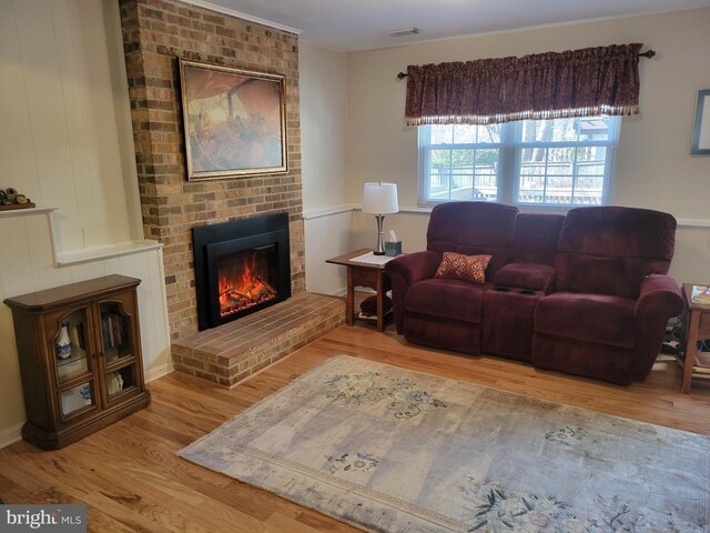 living room featuring a fireplace, wood finished floors, and visible vents