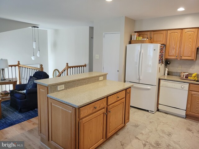 kitchen featuring recessed lighting, a kitchen island, and white appliances