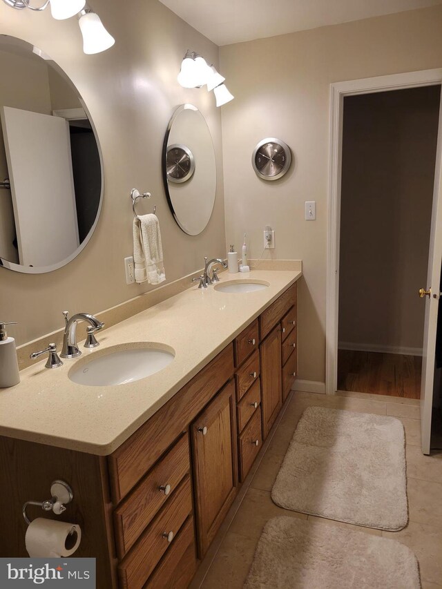 bathroom featuring double vanity, a sink, and tile patterned floors