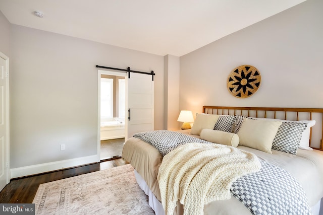 209 11th St NE, Washington, DC 20002 - bedroom with a barn door, wood finished floors, baseboards, and connected bathroom