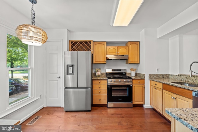 7232 Cherwell Ln, Alexandria, VA 22315 - kitchen with appliances with stainless steel finishes, under cabinet range hood, a sink, dark wood-type flooring, and light stone countertops