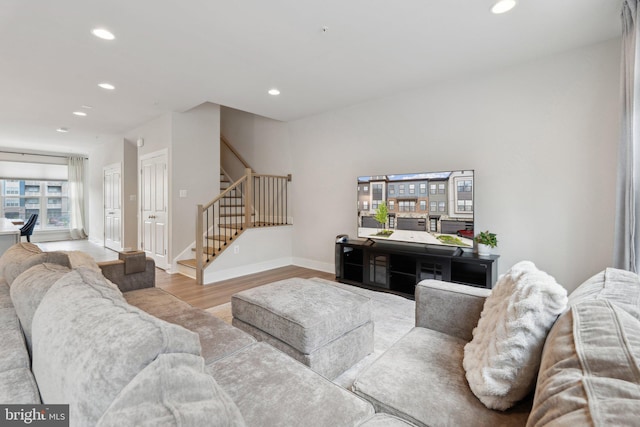 living room with recessed lighting, baseboards, stairs, and wood finished floors