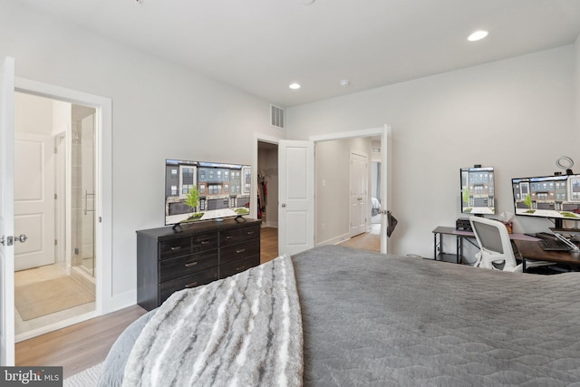 bedroom with recessed lighting, baseboards, wood finished floors, a spacious closet, and visible vents