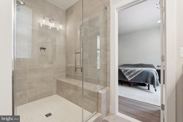 ensuite bathroom with ensuite bathroom, wood finished floors, and a shower stall