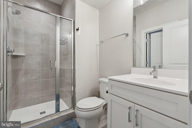 bathroom with vanity, toilet, and a shower stall