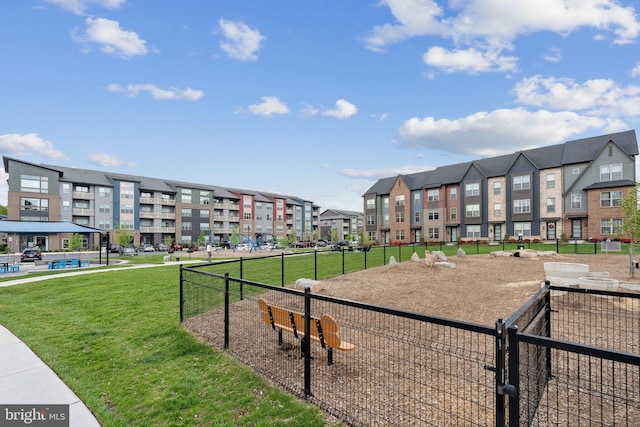 surrounding community with a yard, fence, and a residential view