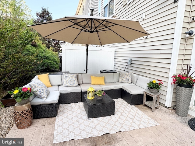 view of patio featuring an outdoor living space, fence, and a deck