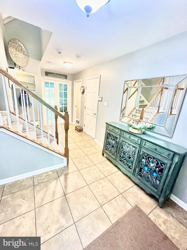 interior space featuring french doors, tile patterned floors, baseboards, and stairway