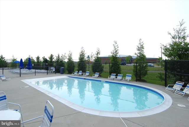 community pool featuring fence and a patio area