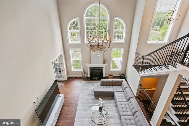 2204 Messina Ct, Eldersburg, MD 21784 - living area featuring a chandelier, a towering ceiling, stairs, baseboards, and wood finished floors