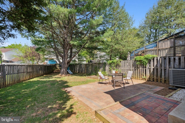 view of yard with a patio, central AC unit, a fenced backyard, and outdoor dining space